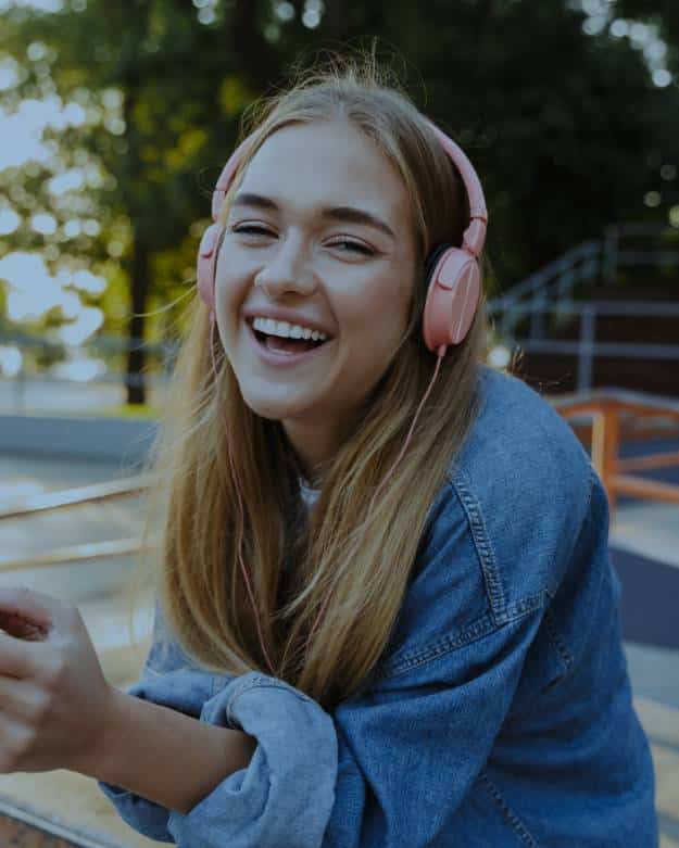 Girl listening to music on pink headphones